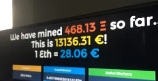 TV Screen that says 'we have mined 468.13 so far. this is 13136.31 euros! 1 Eth = 28.06 euros.