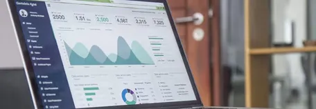 A laptop showing a dashboard with a lot of data visualisation on it.