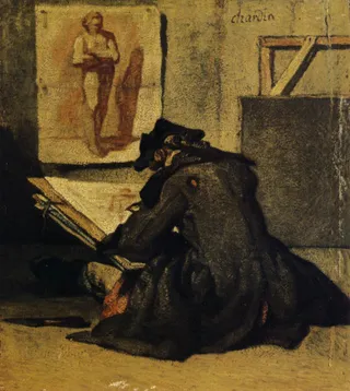 A young artist sits on the floor sketching from a study of a nude figure pinned to the wall. The artist wears a dark coat and hat, hunched over a large sketchpad. The setting is a dimly lit, simple studio space with a rough texture to the walls.