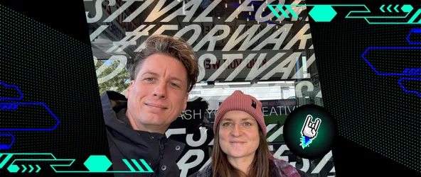 Tommi Gutscher und Vanessa Walter stehen vor einem Schild des Forward Festival Wiens und lächeln in die Kamera.